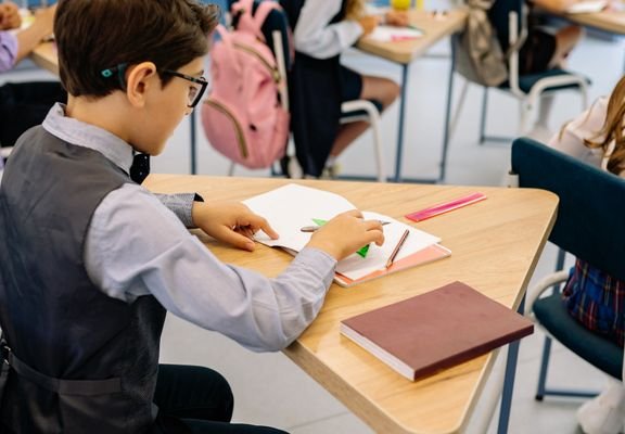 Children working at their desks in a bright classroom