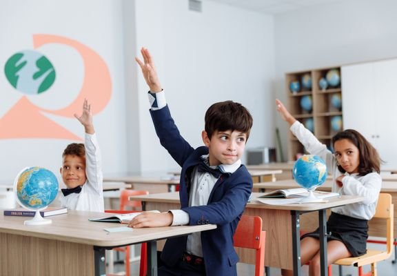 Children raising their hands during a lesson